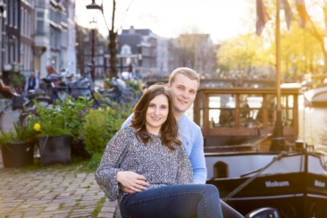 Couple photoshoot, loveshoot, engagement photoshoot: portrait of a couple is sitting near romantic canal Brouwersgracht at sunset, Amsterdam