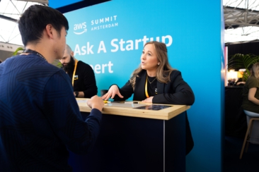 Corporate event photography, conference photography, exhibitor and attendee networking and discussing during AWS Summit in Amsterdam RAI conference centre